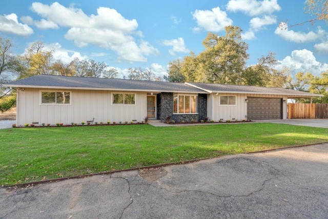 ranch-style house featuring a garage and a front lawn