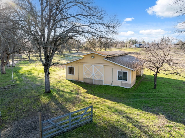 view of outbuilding with a rural view and a lawn