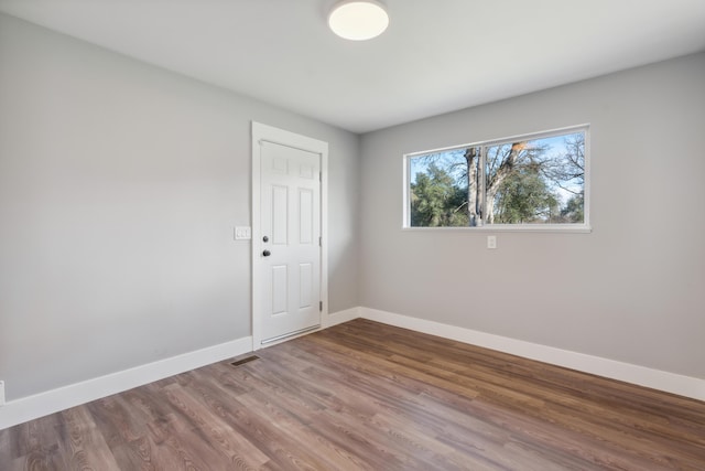 unfurnished room with wood-type flooring