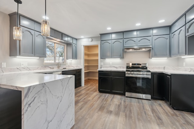 kitchen with sink, hanging light fixtures, stainless steel gas range oven, kitchen peninsula, and light wood-type flooring