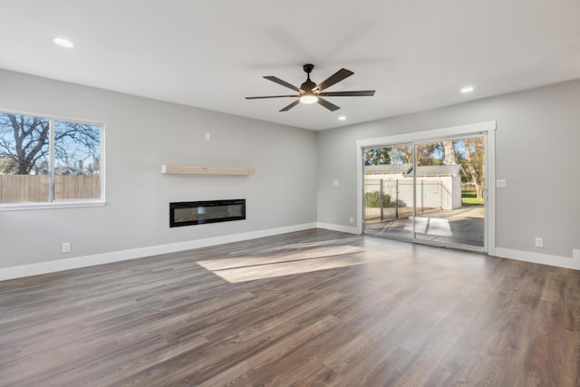 unfurnished living room featuring ceiling fan and dark hardwood / wood-style floors