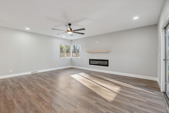 unfurnished living room featuring ceiling fan and hardwood / wood-style floors