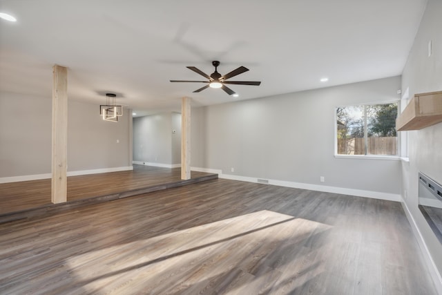 unfurnished living room with dark hardwood / wood-style floors and ceiling fan