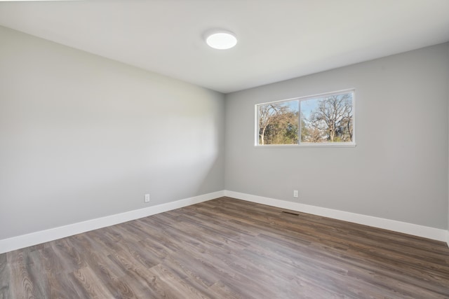 unfurnished room featuring dark wood-type flooring