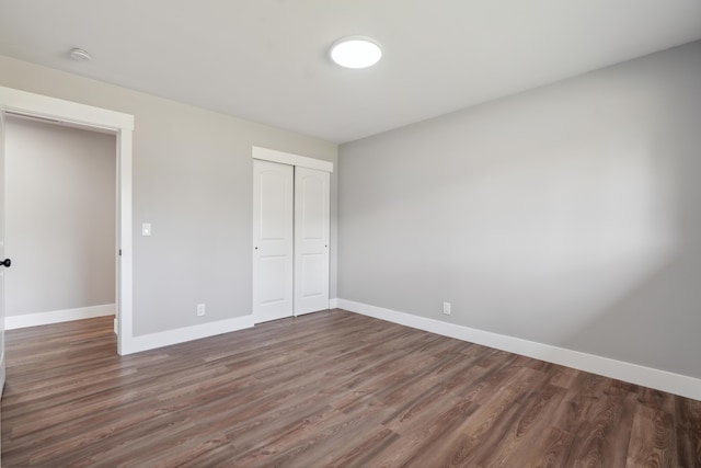 unfurnished bedroom featuring dark hardwood / wood-style floors and a closet