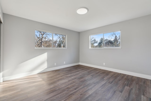 unfurnished room with dark wood-type flooring