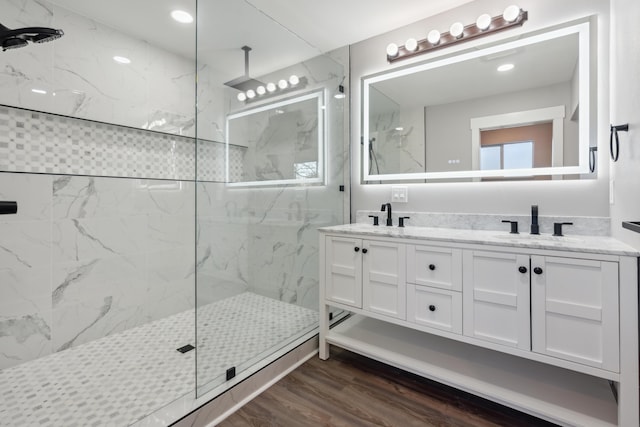 bathroom featuring a tile shower, hardwood / wood-style floors, and vanity