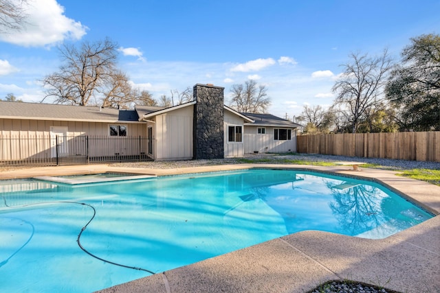 view of pool with a diving board