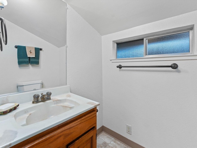 bathroom with vanity, lofted ceiling, and toilet