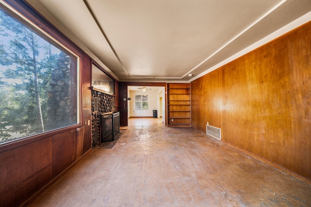 interior space featuring wooden walls and a brick fireplace