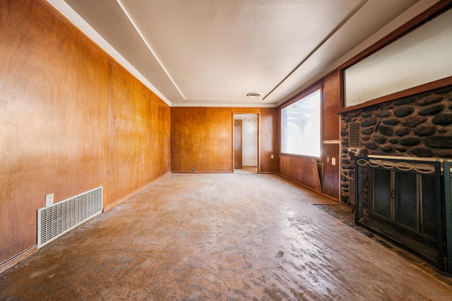 unfurnished living room featuring a fireplace and wooden walls