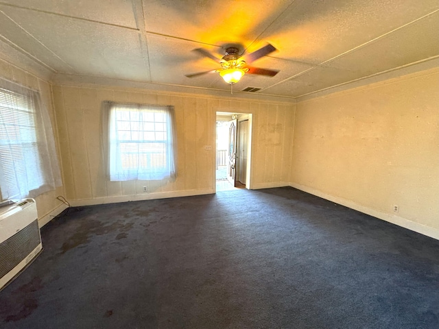 carpeted empty room with crown molding, a wall mounted air conditioner, and ceiling fan