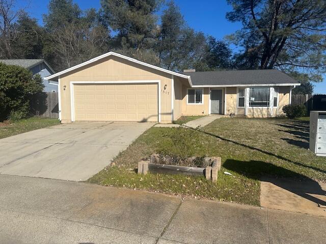 ranch-style home with a garage and a front yard