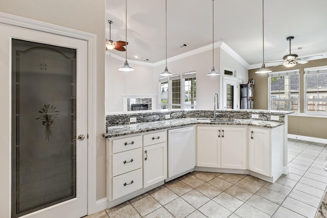 kitchen featuring white cabinetry, dark stone counters, decorative light fixtures, and sink