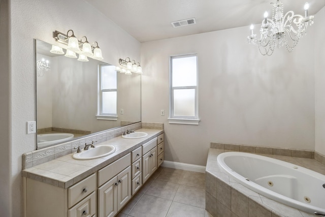 bathroom featuring tiled tub, vanity, and tile patterned flooring