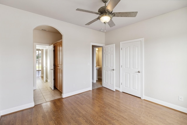 unfurnished bedroom with ceiling fan and light wood-type flooring