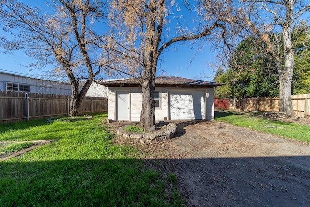 view of outdoor structure featuring a garage and a lawn