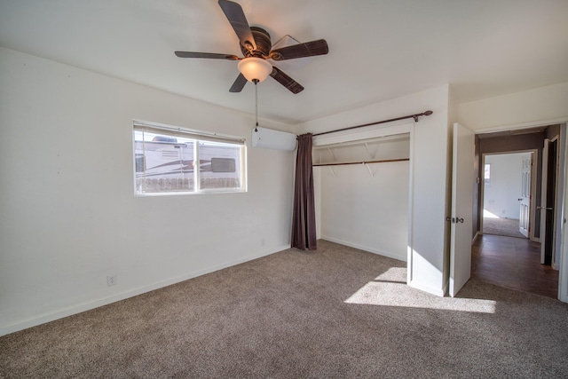 unfurnished bedroom with ceiling fan, a closet, a wall mounted AC, and carpet