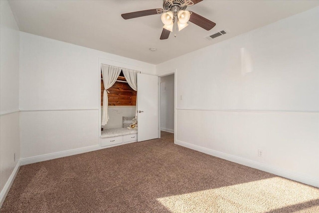 empty room featuring ceiling fan and carpet