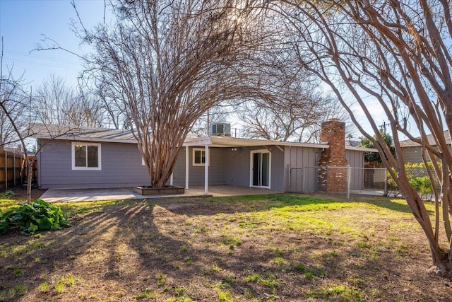 rear view of house featuring cooling unit, a yard, and a patio area