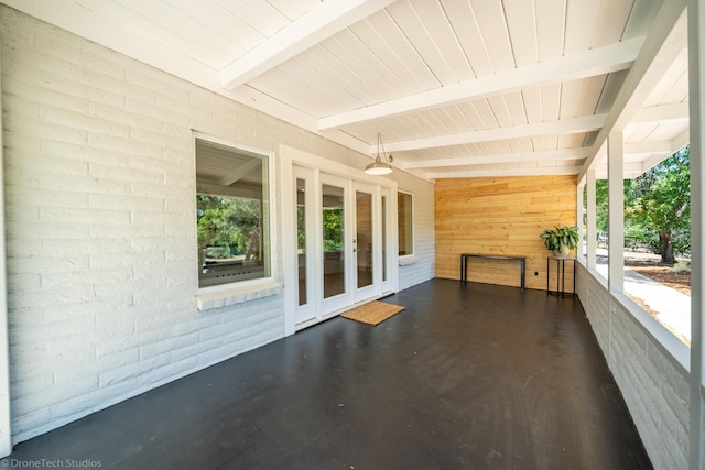 unfurnished sunroom featuring french doors and beamed ceiling