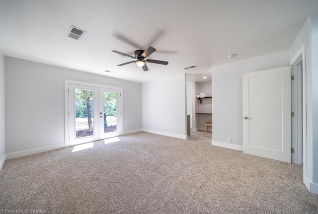 carpeted spare room featuring french doors and ceiling fan