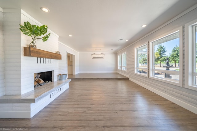 unfurnished living room featuring hardwood / wood-style floors and a large fireplace