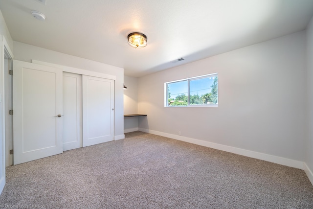 unfurnished bedroom with carpet flooring and a closet