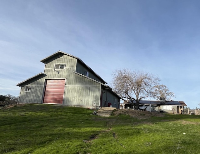 view of home's exterior with a yard, an outdoor structure, and a garage