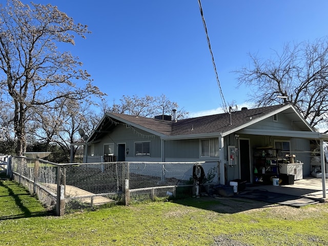 rear view of property featuring a lawn