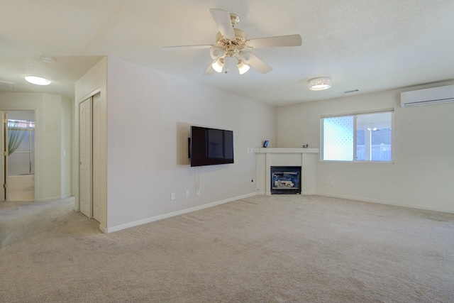 unfurnished living room with a wall mounted air conditioner, light colored carpet, and ceiling fan