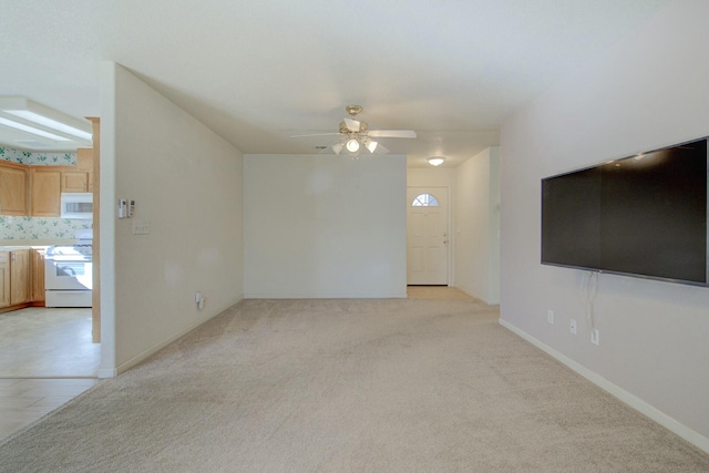 unfurnished living room with light colored carpet and ceiling fan