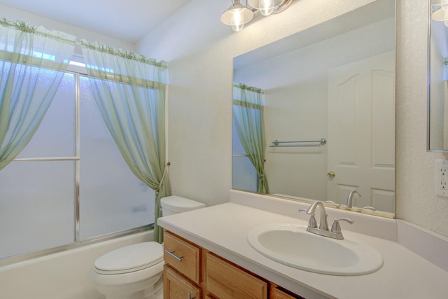 full bathroom featuring vanity, shower / bath combination with glass door, and toilet