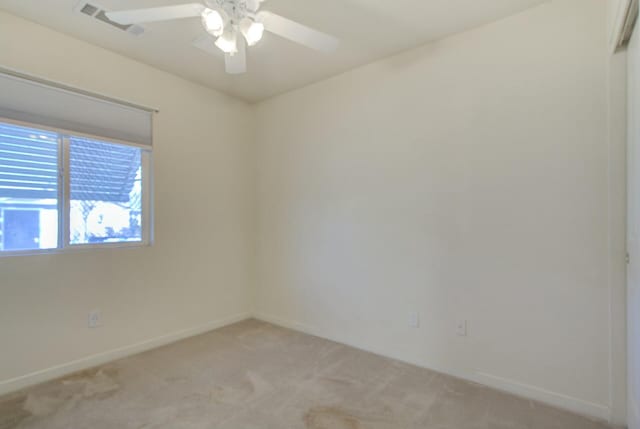 carpeted spare room featuring ceiling fan