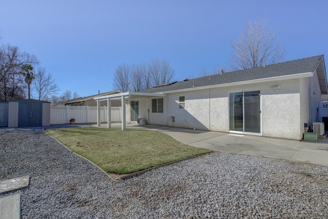 rear view of property with cooling unit, a storage shed, a yard, and a patio