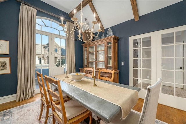 dining area featuring lofted ceiling with beams, hardwood / wood-style floors, french doors, and a notable chandelier