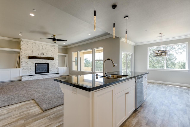 kitchen featuring sink, white cabinetry, plenty of natural light, an island with sink, and pendant lighting