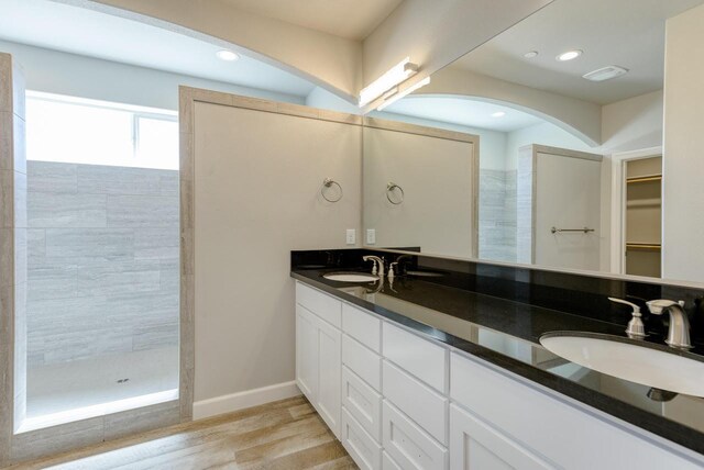 bathroom featuring vanity, hardwood / wood-style flooring, and tiled shower