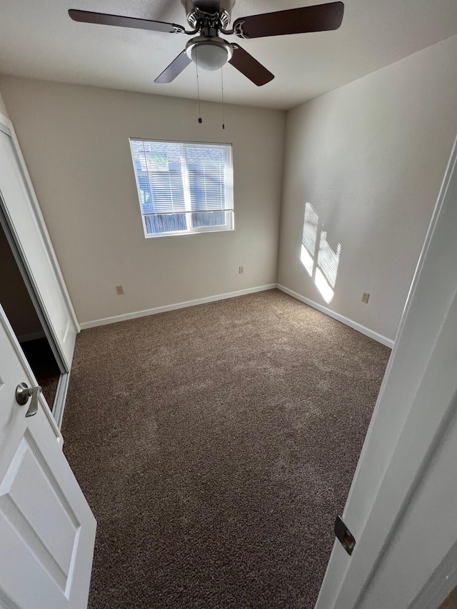 carpeted empty room featuring ceiling fan