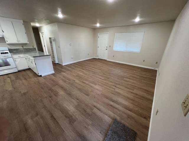 kitchen featuring white cabinetry, white range with gas cooktop, dark hardwood / wood-style floors, and kitchen peninsula