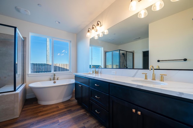 bathroom with vanity, independent shower and bath, and hardwood / wood-style floors