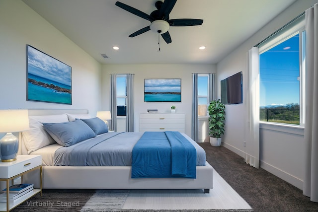 bedroom featuring ceiling fan and dark colored carpet