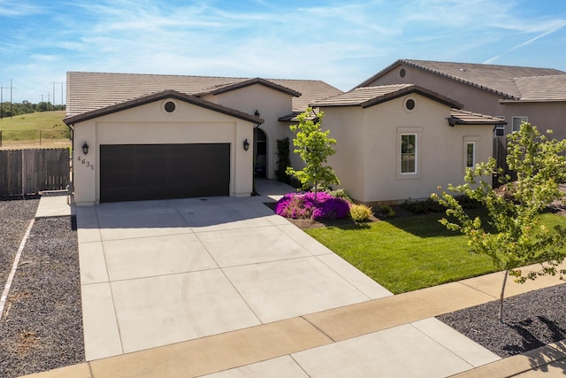 4635 Pleasant Hills Dr, Anderson, CA 96007 - view of front facade with a front yard, fence, concrete driveway, an attached garage, and stucco siding