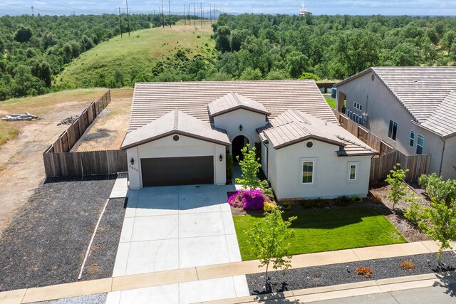 4635 Pleasant Hills Dr, Anderson, CA 96007 - view of front of home with fence, a wooded view, concrete driveway, an attached garage, and stucco siding