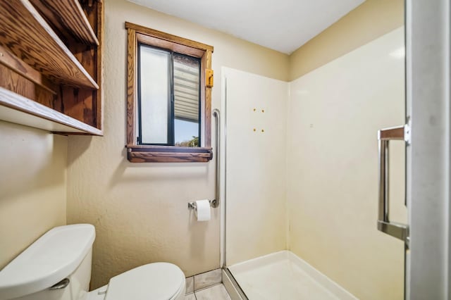 bathroom with a wealth of natural light, a shower, and toilet