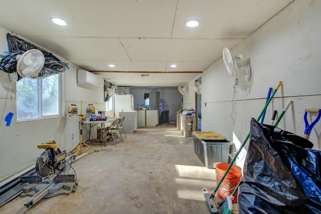 basement with white fridge and a wall mounted air conditioner