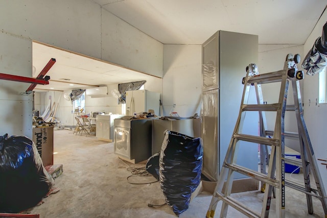 basement with a wall mounted AC and white fridge with ice dispenser