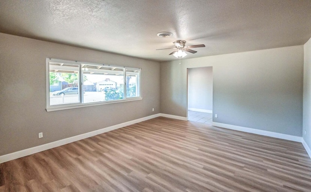 unfurnished room with ceiling fan, hardwood / wood-style flooring, and a textured ceiling