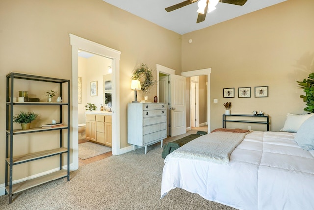 bedroom featuring ensuite bathroom, light carpet, and ceiling fan