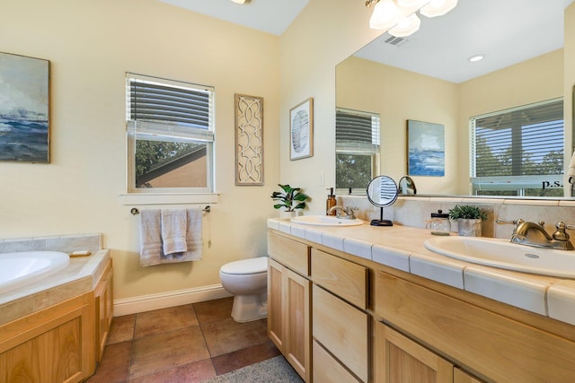 bathroom with tile patterned flooring, vanity, plenty of natural light, and toilet